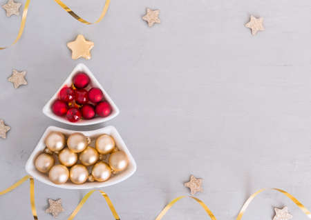 Christmas balls in the shape of a Christmas tree, stars, gray background. Template for holiday information, copy spaceの写真素材