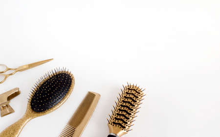 Golden hairdresser tools on a white background, scissors, comb, clip, brush. Hair salon accessories, template with space for text.の写真素材