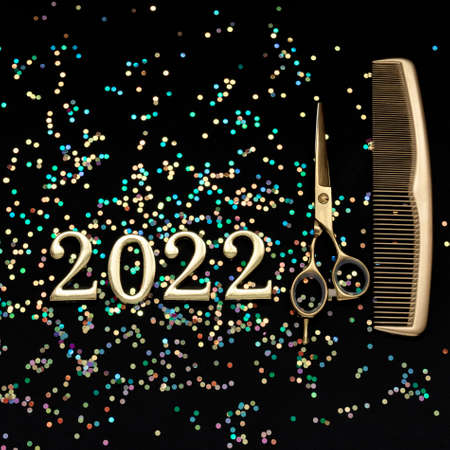 Figures 2022 scissors and comb with confetti on a dark background. Square greeting card of a hairdresser or hair salon.の写真素材