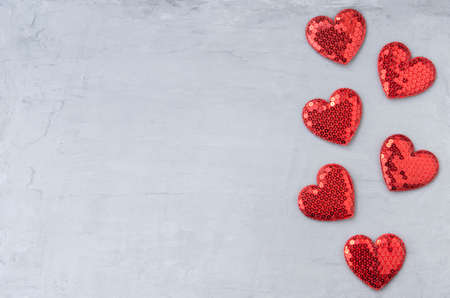 Shiny red hearts with sequins on a gray blue background. Template for design and text for Valentines Day with copy spaceの写真素材