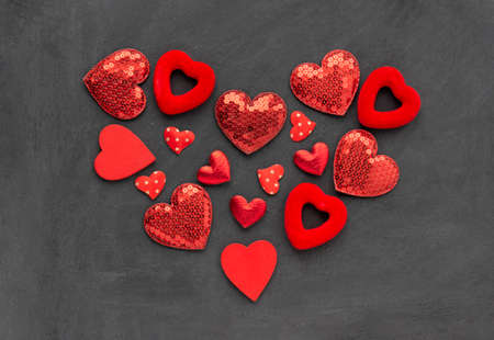 The heart is made of hearts of different sizes and shapes. Textile and wooden elements on a textured...
