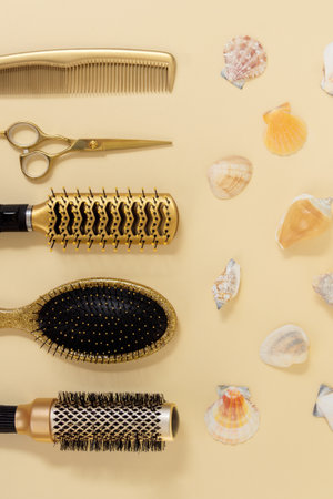 Summer vertical flatlay with hairdressing tools and shells on a yellow background. Hair salon accessories top view.の写真素材