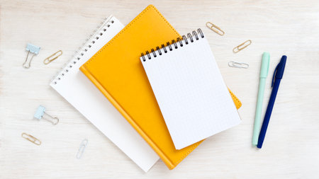 Different notebooks on table top view. Empty notepad with place for message. Bright flatlay...