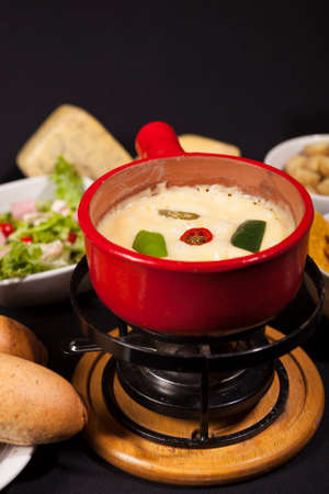 Cheese fondue with bread and vegetables in dish network.の写真素材