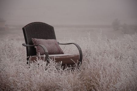 Peaceful empty chair in the winter frosted natureの写真素材