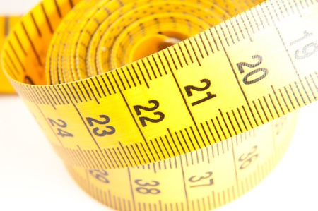 Roll of yellow measuring tape rolled up over white background