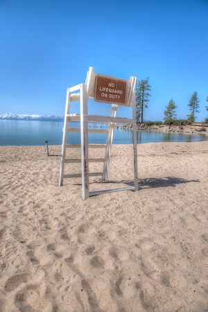 Wooden lifeguard chair in a beautiful beach on the shores of Lake Tahoe under a bright blue skyの写真素材