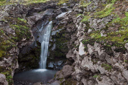 An hidden small waterfall on the mountain on Icelandの写真素材