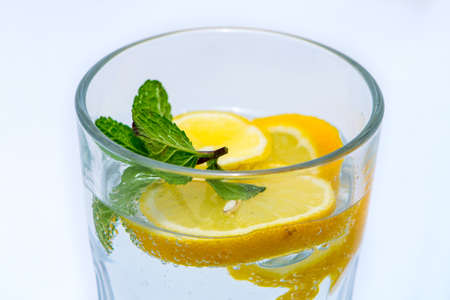 Glass Water with mint and yellow citron half isolated with a white backgroundの写真素材