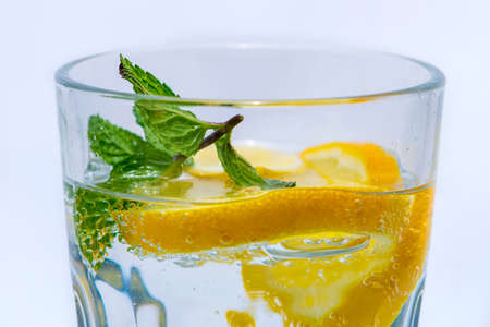 Glass Water with mint and yellow citron half isolated with a white backgroundの写真素材