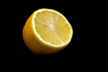 Yellow lemon citrus isolated on a black backgroundの写真素材