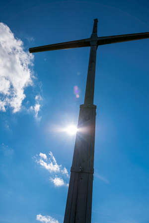 Summit Cross on the top of a mountain with clouds in the sky in the bavarian forestの写真素材