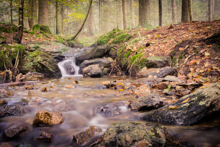 Little Waterfall with stones and rocks in the autumn in the bavarian forestの写真素材