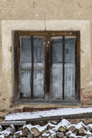 Window in the winter with snowflakes and firewoodの写真素材
