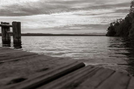 Footbridge at a lake with clodus on the sky at the sunsetの写真素材