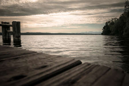 Footbridge at a lake with clodus on the sky at the sunsetの写真素材