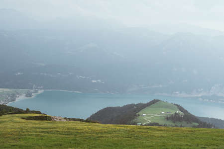 View from top of a mountain in austria with clouds on the sky and mountains in the backgroundの写真素材