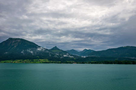 Lake called Wolfgangsee in Austria with mountian in the background and clouds on the skyの写真素材