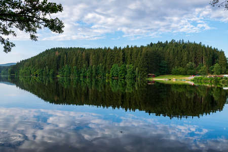 Lake with Reflection on the Water and Trees in the background and Clouds on the sky in the bavarian forestの写真素材