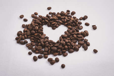 Heart with fresh roasted coffee beans on a white background with a great aromaの写真素材