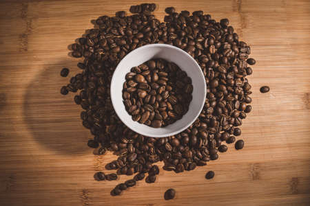 Cup of Coffee Beans roasted on a wooden table with fresh bean with great aromaの写真素材