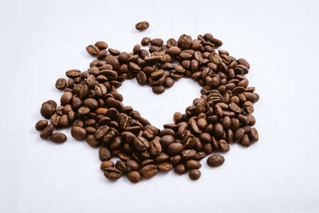 Heart with fresh roasted coffee beans on a white background with a great aromaの写真素材