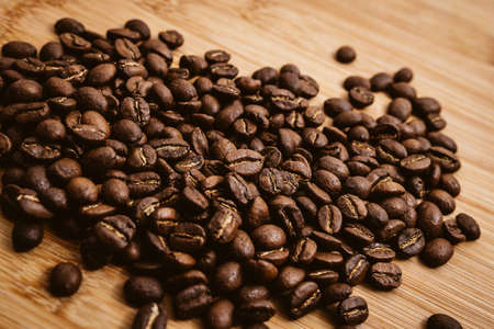 Coffee beans roasted on a wooden table with much of beans with a great aromaの写真素材