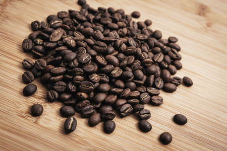 Coffee beans roasted on a wooden table with much of beans with a great aromaの写真素材