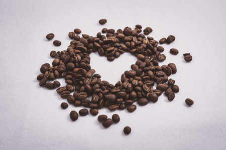 Heart with fresh roasted coffee beans on a white background with a great aromaの写真素材