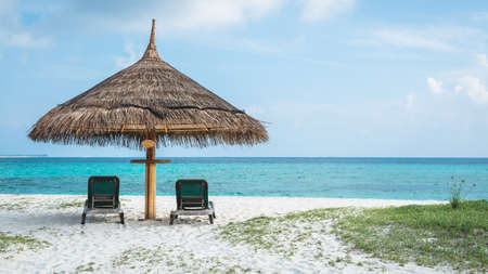 Lying on the white sandy beach of the Maldives overlooking the turquoise seaの写真素材