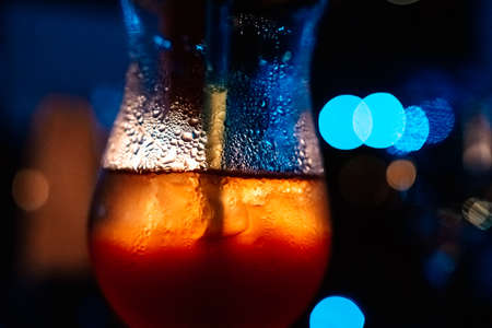 Cold drinks with sparkling water on the glass in the party lightの写真素材
