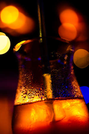 Cold drinks with sparkling water on the glass in the party lightの写真素材