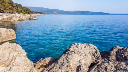 A beautiful view on the coastal line from a little cliff. The water has very deep color. On the sides of the cliff there are coniferous trees. Hard to reach the water as the stones are very sharpの写真素材