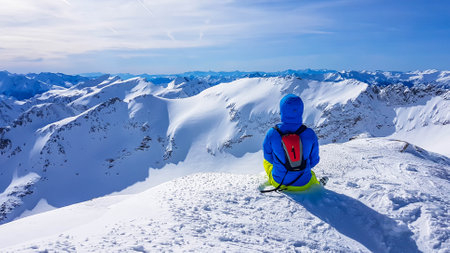 Skiing young man sitting on the snow in Moelltaler Gletscher, Austria, enjoying the view. Lots of...