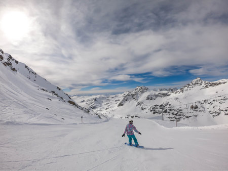 A snowboarder going down the slope in Moelltaler Gletscher, Austria. Perfectly groomed slopes. High...