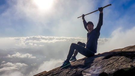 A young man sitting on the side of volcano Inerie in Bajawa, Flores, Indonesia. He is surrounded by...