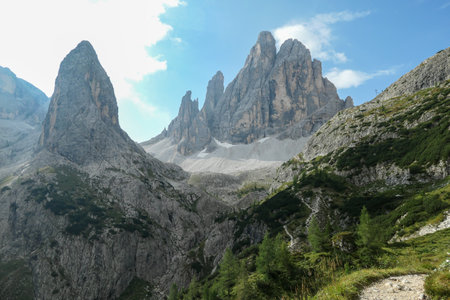 A panoramic view on Italian Dolomites. There are many high and sharp peak in front, with many...