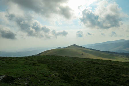 A panoramic view on the distant Grosse Speikkogel in Austrian Alps. The mountains around are lush...