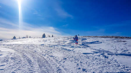 A girl with a snowboard in her hand walking on a powder snow in Bad Kleinkirchheim, Austria. There...