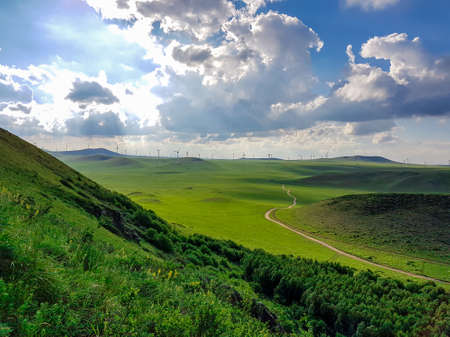 A panoramic view on a hilly landscape of Xilinhot in Inner Mongolia. Endless grassland with a few...