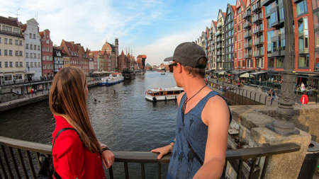 A couple enjoying the view on the shores of Martwa Wisla flowing through Gdansk in Poland, with...