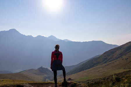 A woman enjoying the view on Caucasus mountains in Georgia. High mountain chains in front. There...