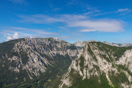 A panoramic view on the Alpine mountain chains in Austria, Hochschwab region. The slopes are partially overgrown with small bushes, higher parts baren. Clear and sunny day. Serenity. Hiking in Alpsの写真素材