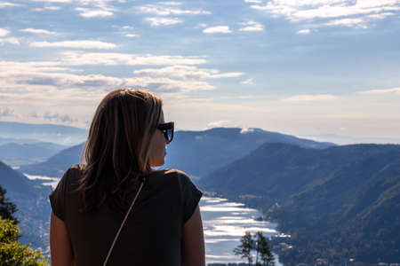 A woman standing at the viewing platform of a chapel at the top of Oswaldiberg with the view on the...