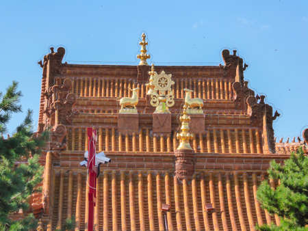 A close up on red rooftop of a Buddhist temple with golden decorations on it in Hohhot, Inner...