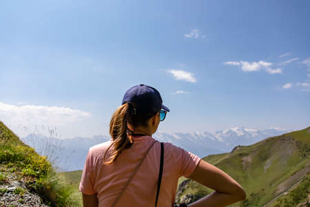 A woman enjoying the amazing views on the mountain ridges in the Greater Caucasus Mountain Range in Georgia, Samegrelo-Upper Svaneti Region. Alpine pasture along the path. Wanderlust. Koruldi Lakesの写真素材