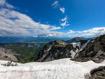 Panoramic view in spring near Frauenkogel on mountain peaks in the Karawanks, Carinthia, Austria. Borders Austria, Slovenia, Italy. Triglav National Park. Alpine meadows. Alm. Snow fields meltingの写真素材