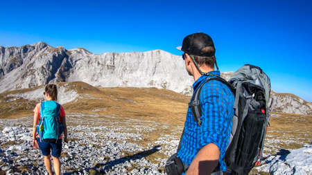 A couple hiking in Hochschwab region in Austrian Alps. The man is taking a selfie. The flora...