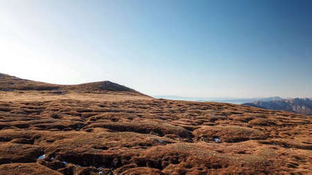 A panoramic view on the plain on top of a mountain in Hochschwab region in Austrian Alps. The flora overgrowing the slopes is turning golden. Autumn vibes. Sharp and steep mountain chain. Wildernessの写真素材
