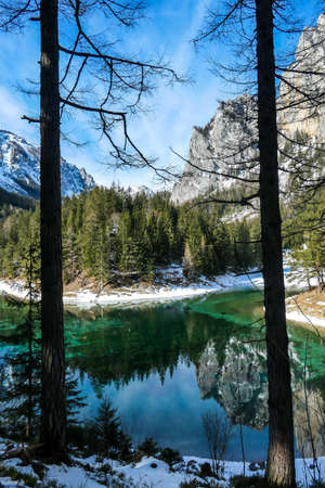 An idyllic view on Alpine Green Lake in Austria, seen from a small hill around the lake, through the...